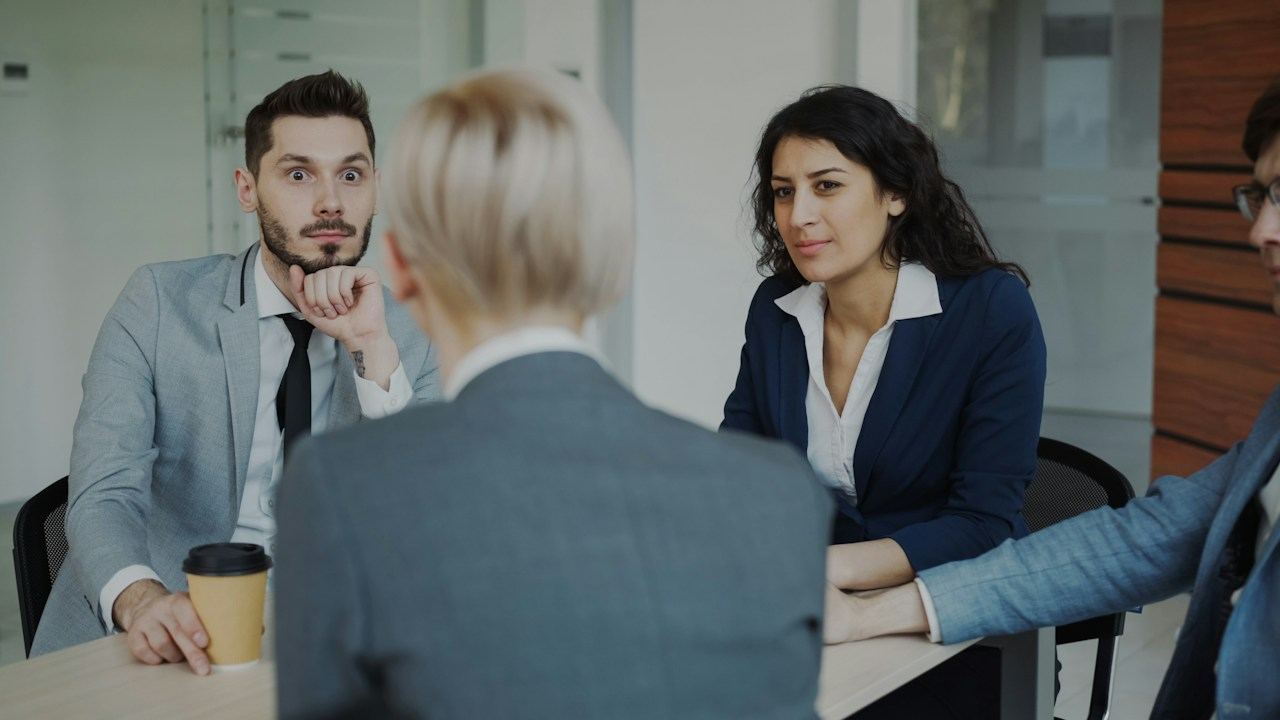 Colleagues discussing work around a meeting table